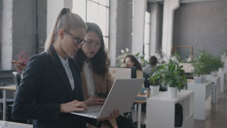 businesswomen collaborating on a laptop in a modern office