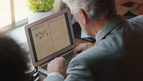 professional businessman using digital laptop computer in cafe working browsing emails networking online looking pensive brainstorming in busy restaurant