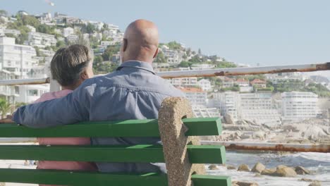 feliz pareja de ancianos afroamericanos sentados en un banco en el paseo marítimo, cámara lenta