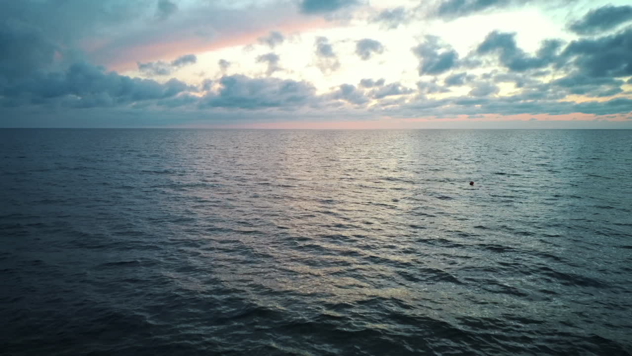 일몰 후 바다 위로 뒤로 날아가는 드론