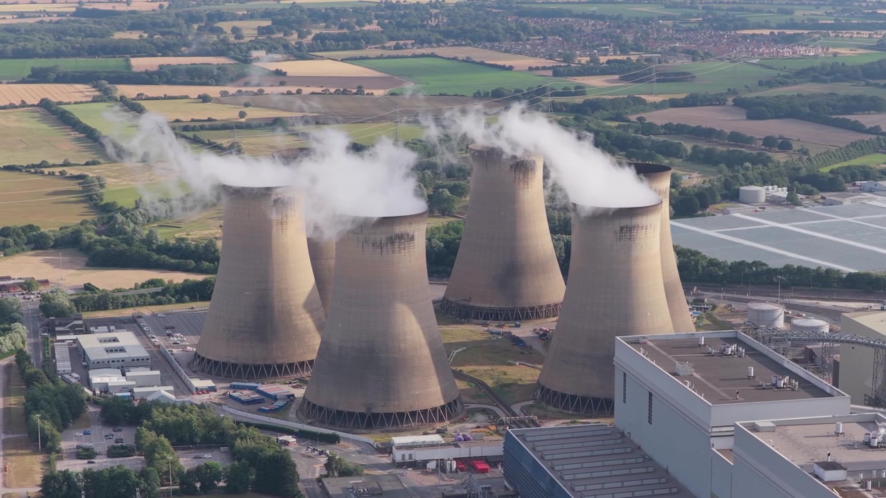 Una vista aerea della centrale elettrica Drax del North Yorkshire, con torri di raffreddamento che emettono vapore denso durante la produzione industriale di elettricità in una giornata estiva