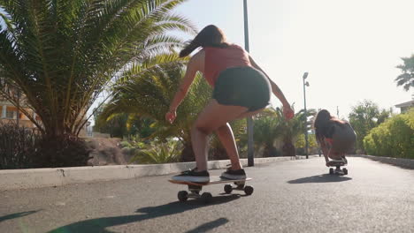 two young hispanic women savor slow-motion skateboarding on island paths, enveloped by the sunset's luminous touch and palm trees. this represents happiness and dedication to well-being