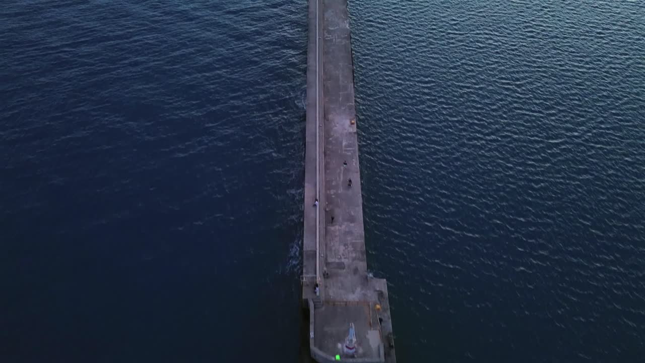 Aerial high angle, bird's eye view of iconic one kilometer pier at port of Kalamata, push in, tilt up shot, revealing the port on distance 4k