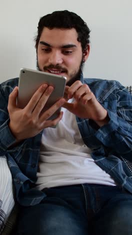 young man expressing different emotions while using tablet