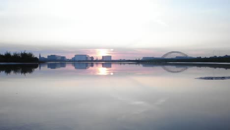 Sonnenaufgang-Hinter-Einem-Gebäude,-Aufgenommen-Während-Einer-Slowmo-Truck-Drohnenaufnahme-An-Einem-Wunderschönen-Holländischen-See