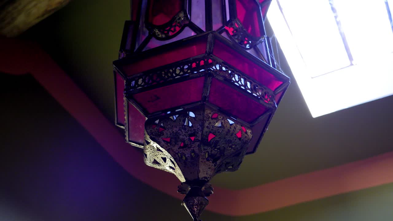 천장에 매달려 있는 밝은 추상 유리 조명 덮개 주위를 회전하는 샷