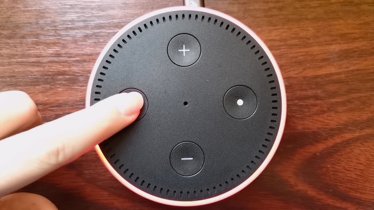 Girl turning on the microphone  on the Amazon Alexa Echo Dot device