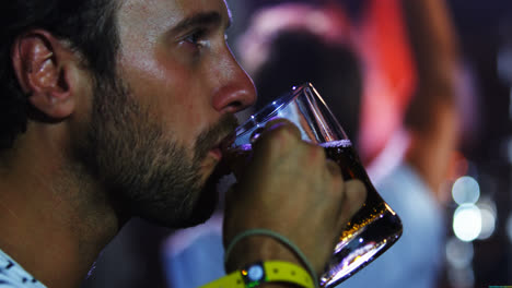 man having a mug of beer at a concert 4k