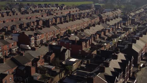 aerial view reveals rows of historic terraced house rooftops in dentons green, st helens, tilt down shot