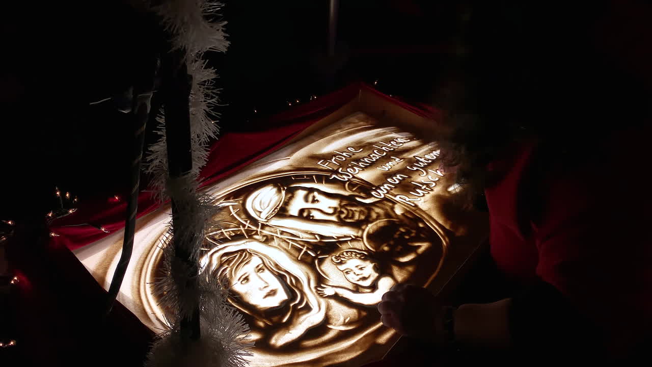 Primo piano di una donna talentuosa che disegna animazioni di sabbia, storia di Natale