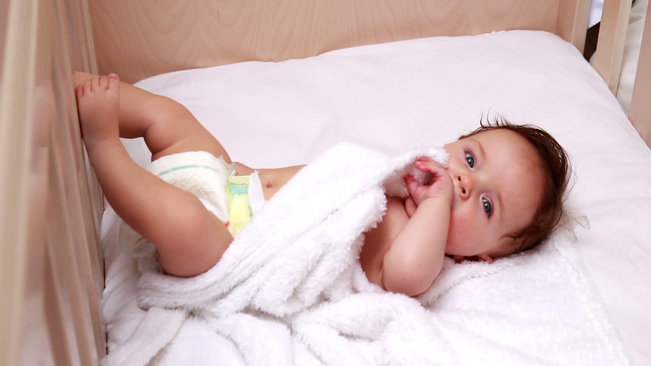 bebé en pañales acostado en la cuna