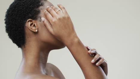 feliz mujer afroamericana con cabello oscuro corto en fondo gris con espacio de copia, cámara lenta