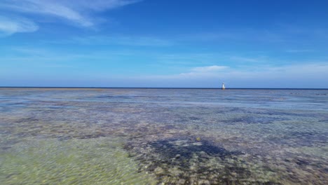 dynamic aerial forward motion flying quickly above the shallow coral-filled waters of my hoa lagoon in phan rang, vietnam.