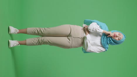 cuerpo lleno de mujer musulmana asiática pensando en algo y mirando a su alrededor mientras estaba de pie en la pantalla verde estudio de fondo