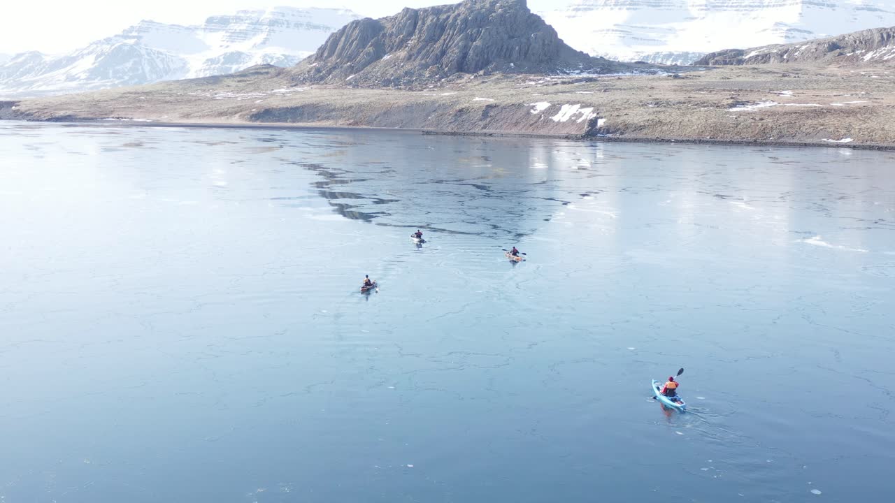 reydarfjordur 피요르드의 잔잔한 반쯤 얼어붙은 물에서 카약 4명, 공중