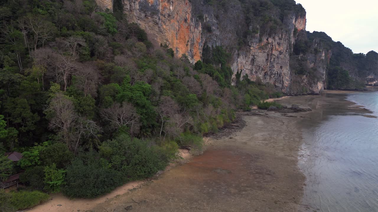 Limestone karst formations at low tide, Railay Beach Krabi, Thailand. Beautiful aerial view flight fly reverse drone