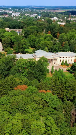 lush greenery surrounding the beautiful historic palace. urban landscape and farmlands at backdrop. top view. vertical video