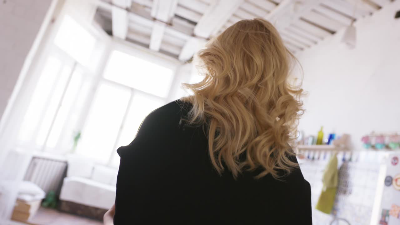 밝은 부에서 창밖을 바라보는 여자.