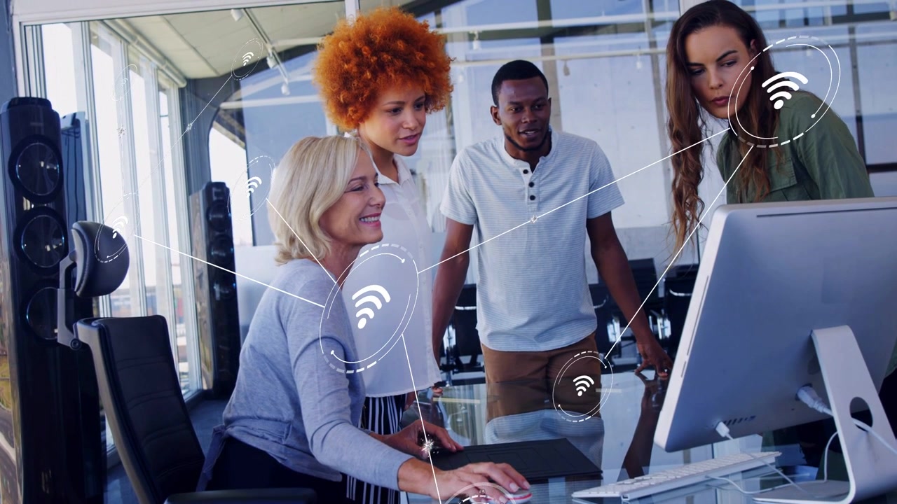 Vertical video: Clicking seated lead showing network on monitor at table, in gray top, team leaning