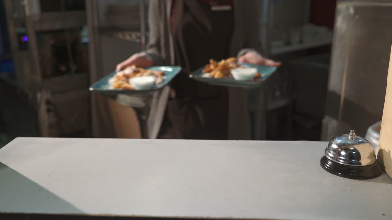 Waiter serving clients. Dish with potatoes in hands of waiter in restaurant