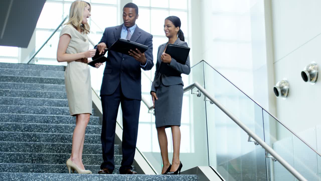 jóvenes empresarios multiétnicos que utilizan tecnología inalámbrica