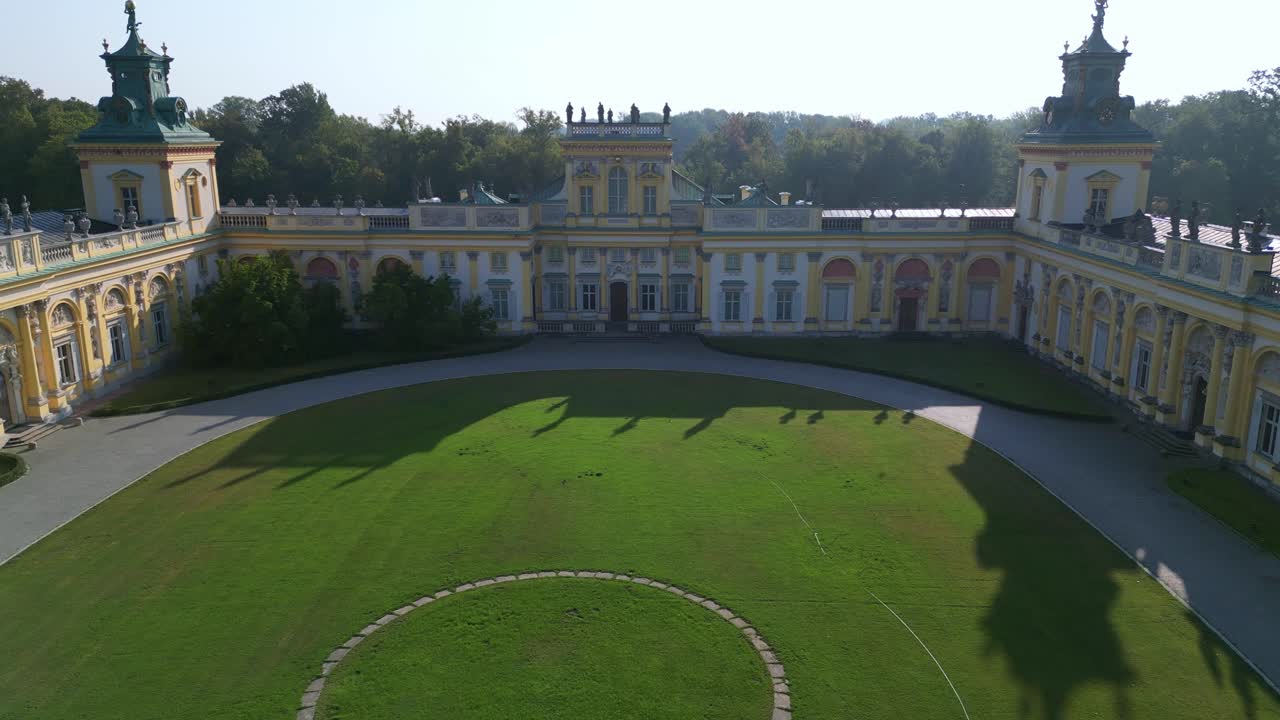Drone captures Warsaw’s Wilanów Palace in morning sunlight and shadow, highlighting baroque architecture, expansive gardens, and cultural heritage landmark in Poland