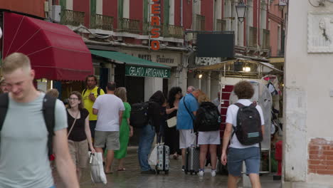 people walking on a busy street in venice, italy