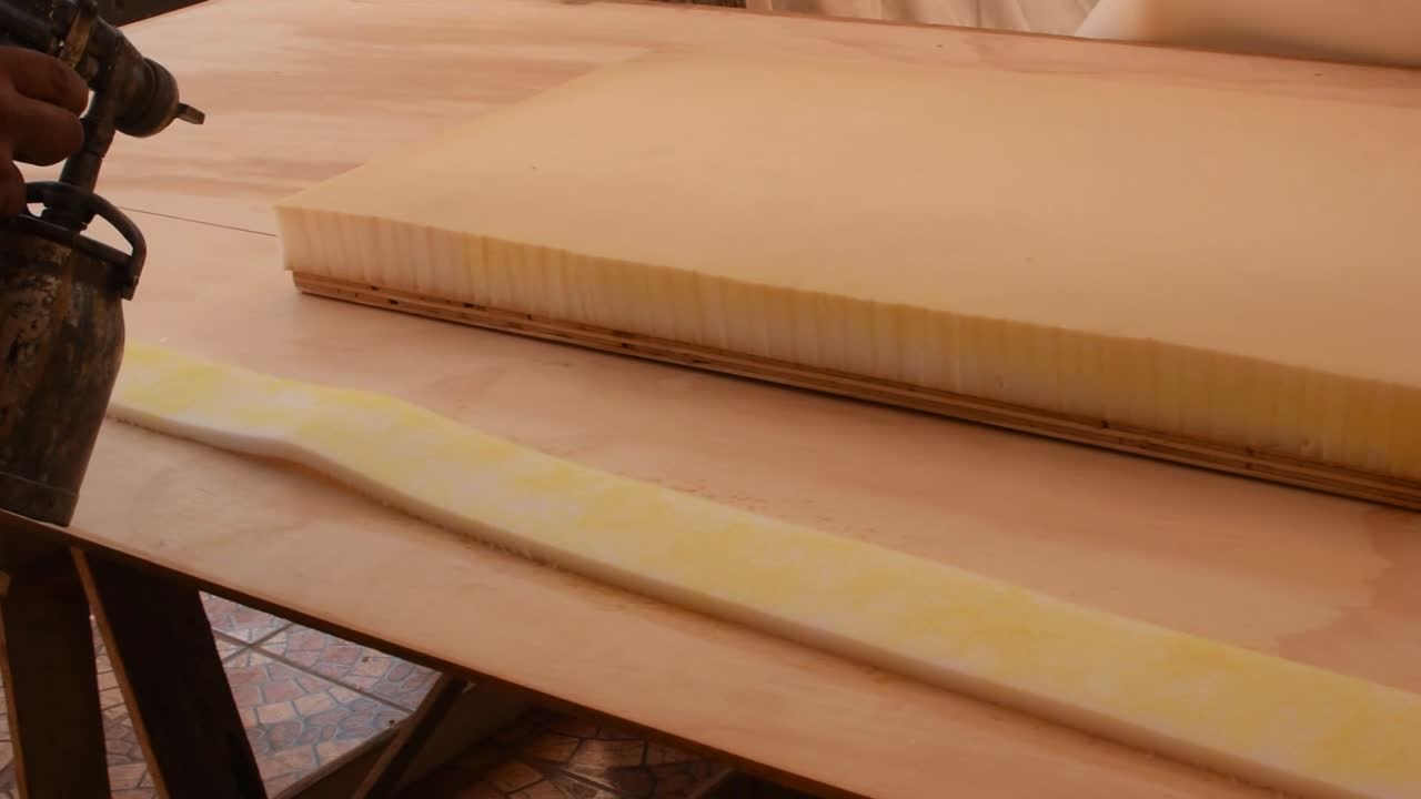 실내 장식품 스펀지에 스프레이 건으로 접착제를 바르는 실내 장식업자-왼쪽 팬