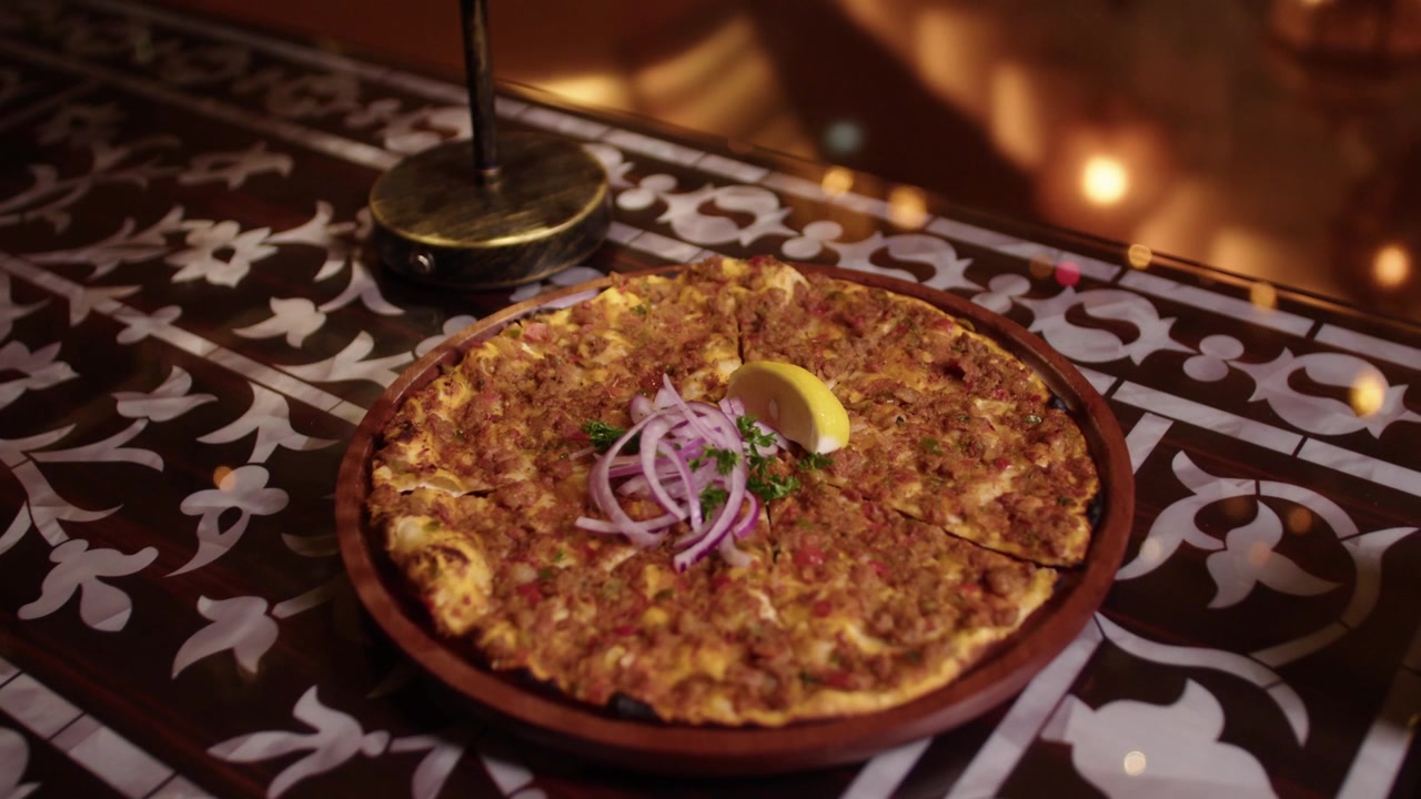 Delicious traditional Turkish lahmacun served on a wooden plate in a classic restaurant