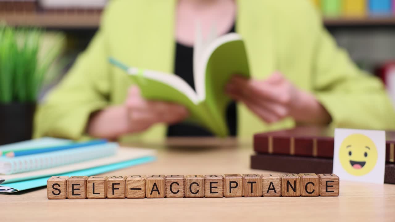 Image depicting the concept of self-acceptance with wooden blocks and a person reading a book