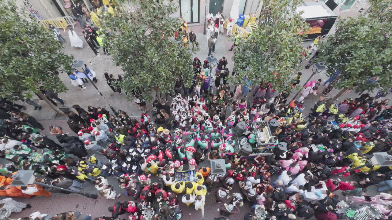 Vista aérea de una gran multitud de personas disfrazadas en un festival callejero.