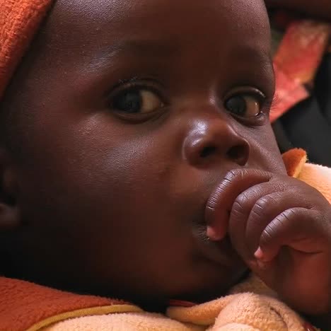 a baby girl sucking her thumb