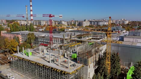 New construction site in the city. Creation of modern residential buildings. Several cranes operate at the site. Aerial view construction site.