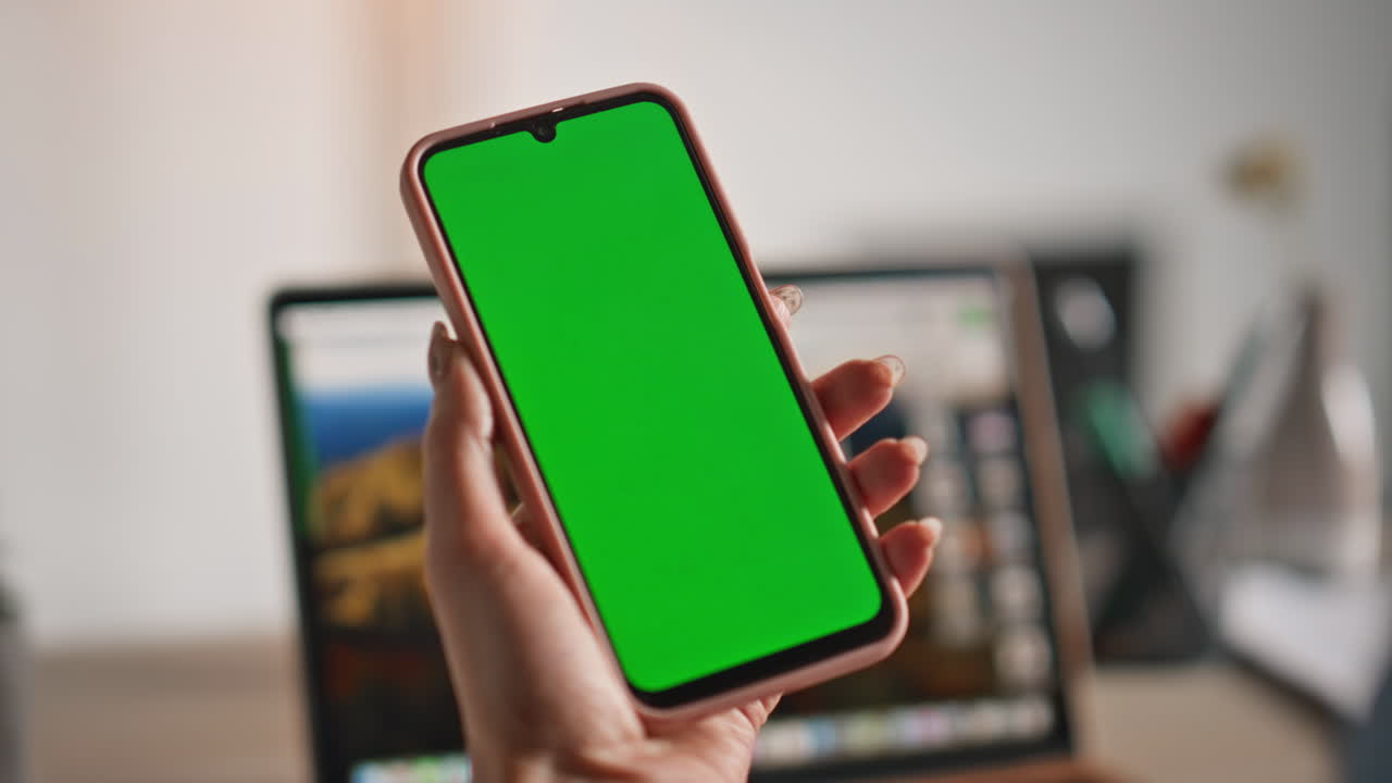 User scrolling chroma key cellphone in office closeup. Unrecognizable hands