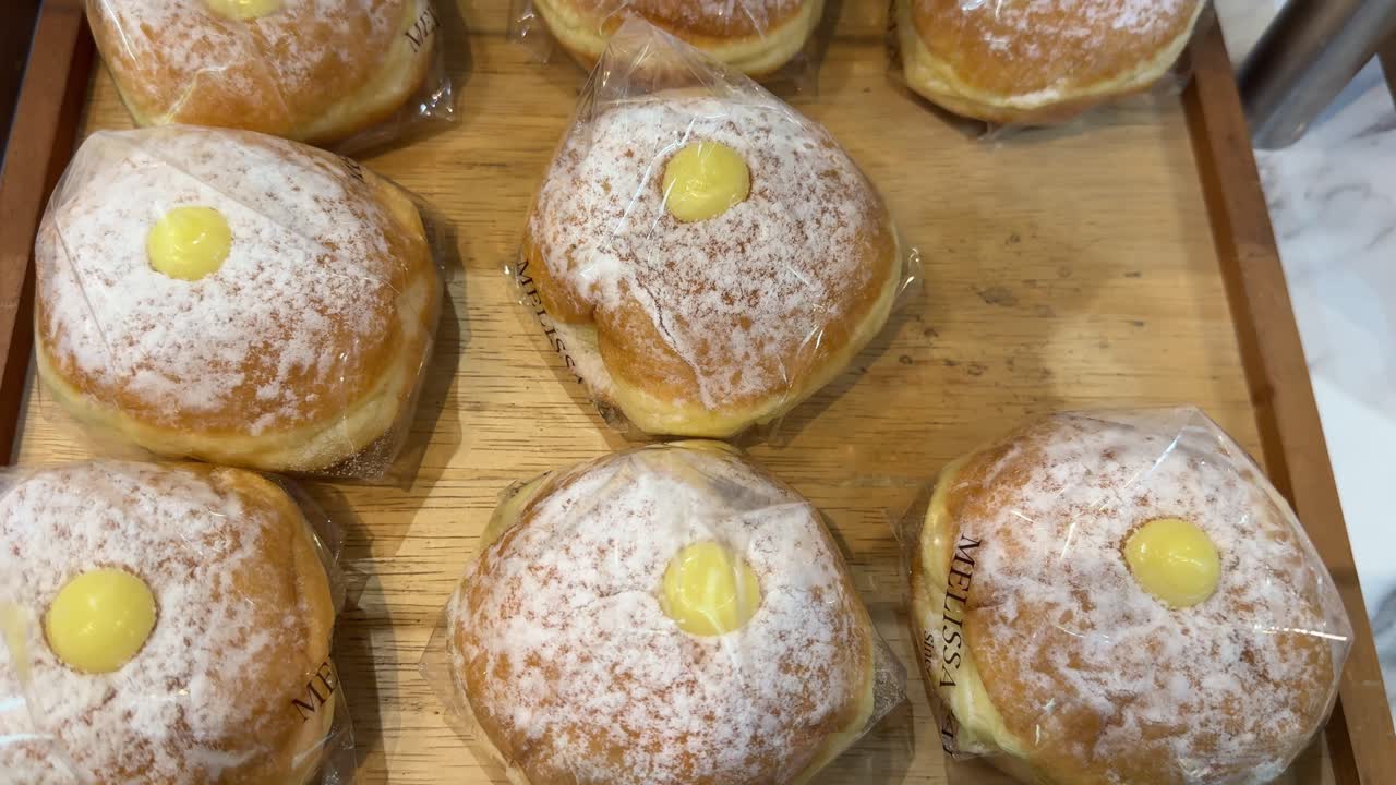 Süße Puderzucker-Donuts mit Cremefüllung in einer Bäckereiauslage