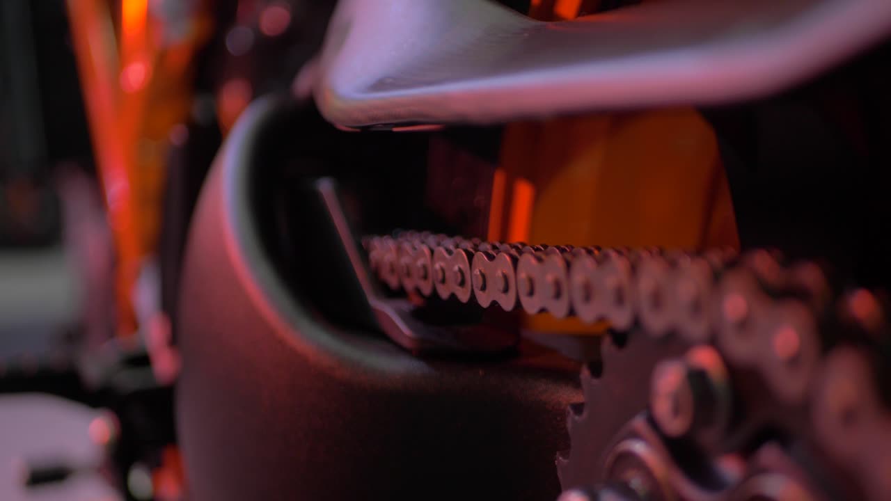 Close Up On The Chain Of An Orange KTM Motorcycle Superduke 1290 in an event with good lights and bokeh