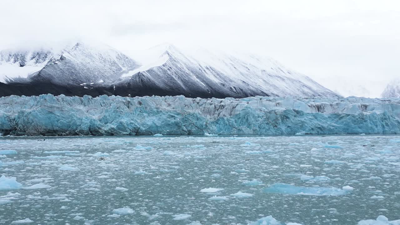 빙하 앞의 파란색 얼음 블록과 산을 배경으로