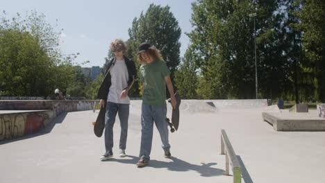 caucasian friends walking in skatepark.