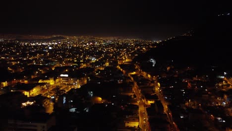 Imágenes-De-Drones-De-Las-Luces-Nocturnas-De-La-Ciudad,-Yendo-Hasta-El-Horizonte-Lejano