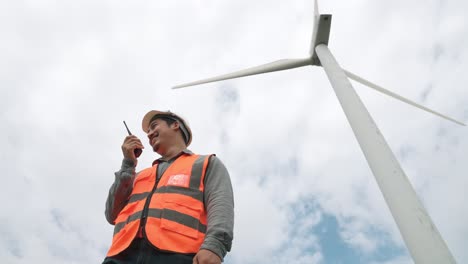 progressive engineer working with the wind turbine, with the sky as background.