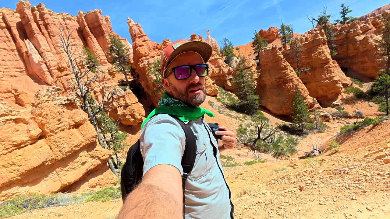 Homem Gravando Vídeo Selfie Enquanto Faz Trilha em um Cânion no Deserto
