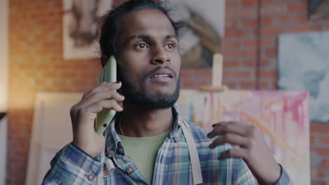 artist talking on phone in art studio