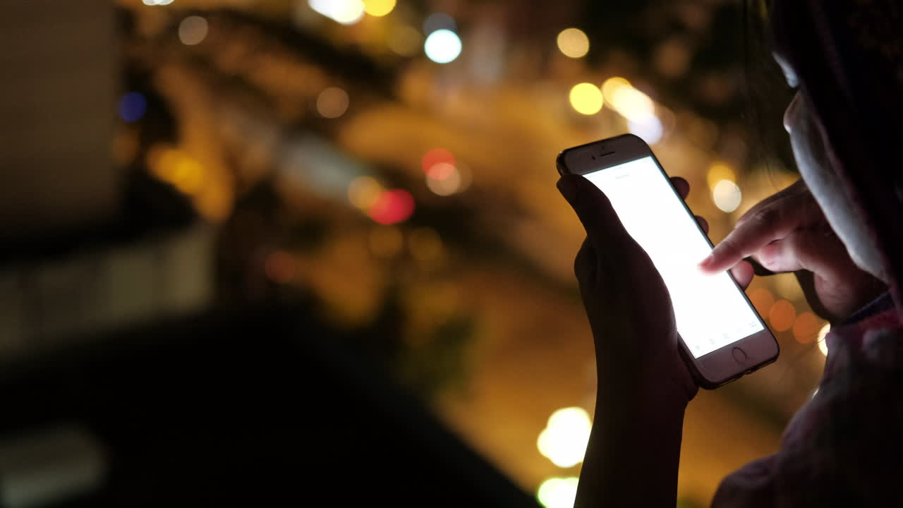 mujer usando teléfono inteligente por la noche