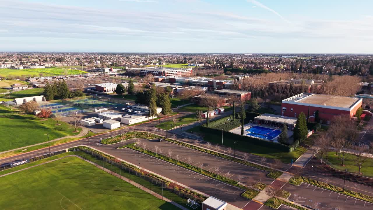Una vista dall'alto mostra il Cosumnes River College che risplende sotto i cieli dell'ora d'oro, con la luce solare che accentua l'equilibrio tra gli edifici accademici e gli spazi verdi circostanti