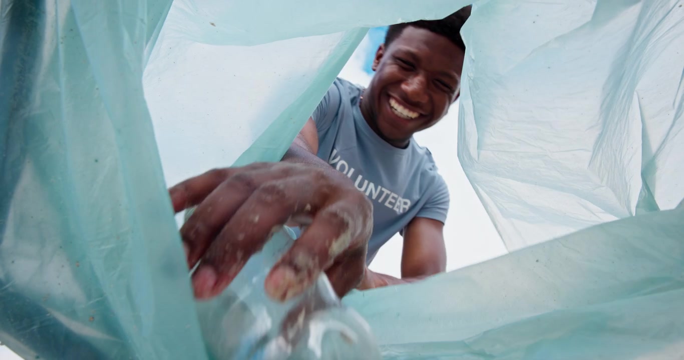 Diverse Volunteers Collecting Plastic Waste in Trash Bag