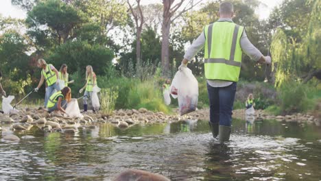 Mid-adults-with-yellow-vest-volunteering-during-river-clean-up-day