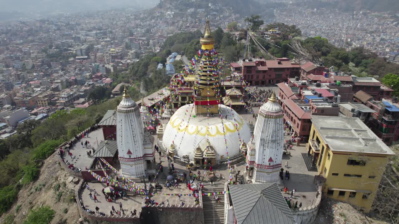 A breathtaking drone view of Swayambhunath Stupa overlooking Kathmandu City, capturing its sacred presence, hilltop beauty, and the vibrant urban sprawl surrounding this iconic heritage site