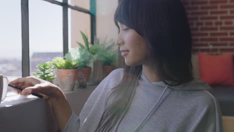 Retrato-Hermosa-Mujer-Asiática-Usando-Un-Teléfono-Inteligente-En-Casa-Navegando-Mensajes-Disfrutando-De-Un-Estilo-De-Vida-Relajado-Sonriendo-Feliz-Mujer-Enviando-Mensajes-De-Texto-Por-Teléfono-Móvil-Luciendo-Segura