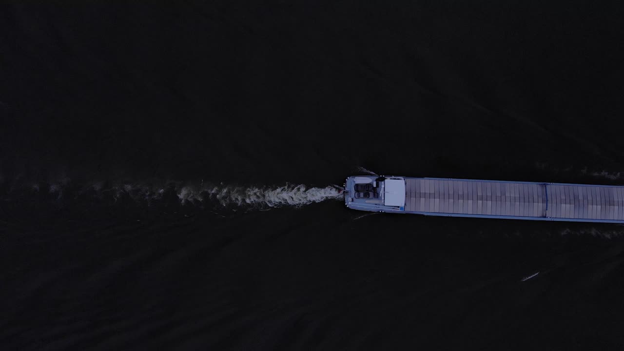 네덜란드 노르드 강에서 일몰 시 화물을 운반하는 바지선 항법을 통과하는 강 화물선의 여파