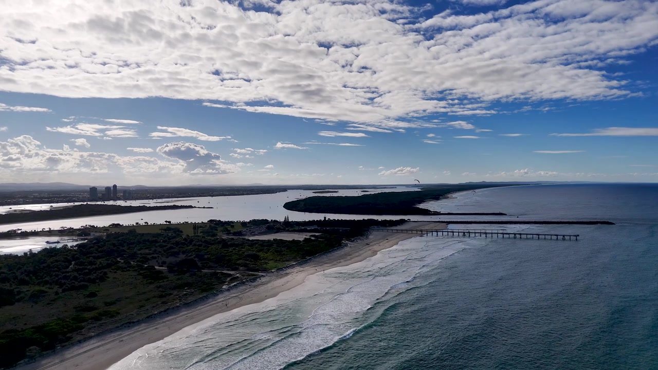 Ripresa aerea con drone di onde che si infrangono sulla costa di Main Beach nel Queensland, Australia